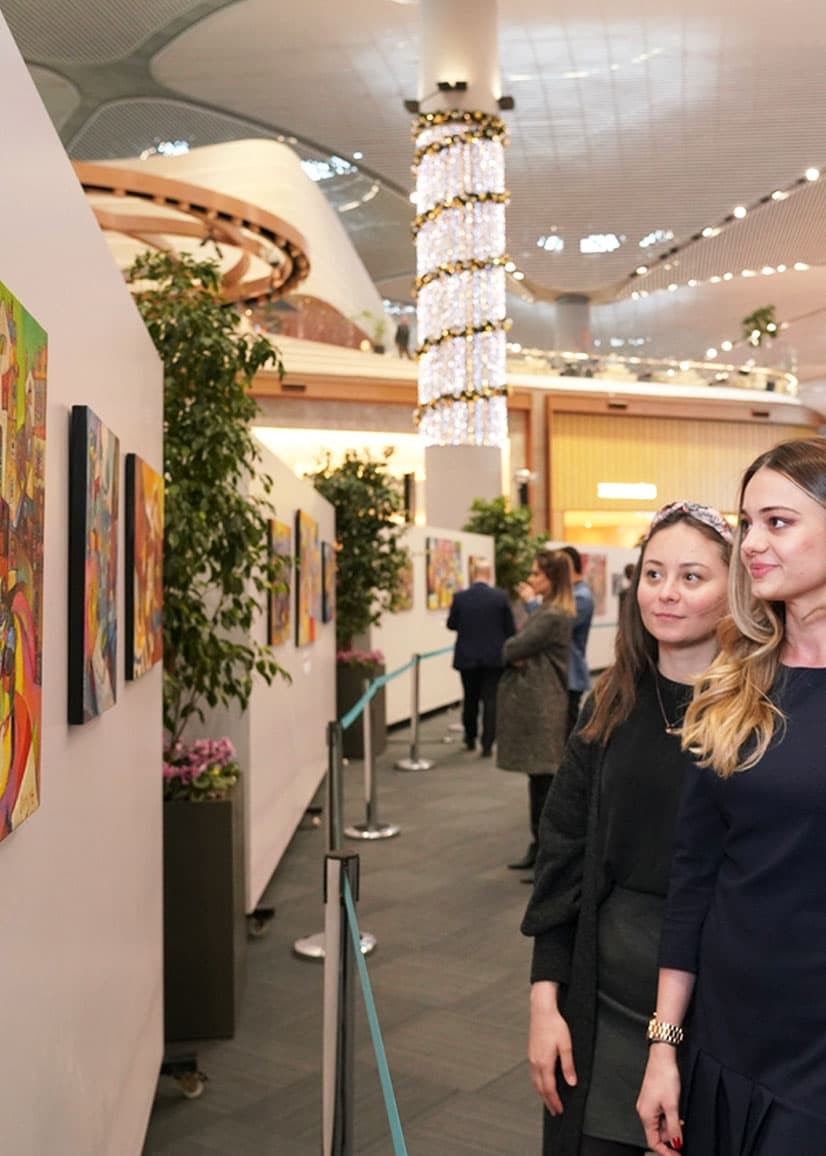 two woman looking at the painting