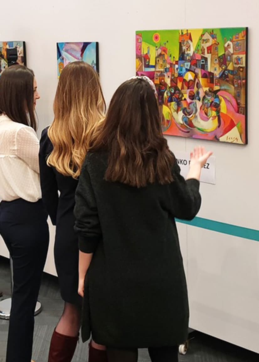 three women looking at the painting